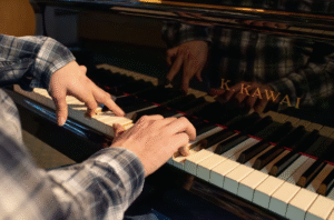 Jacob's hands playing the piano with just six fingers.
